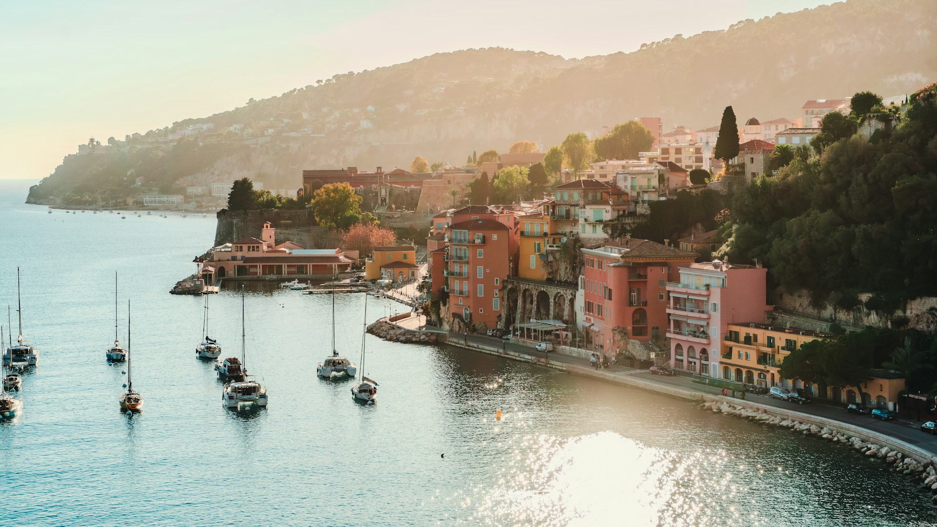 Coastal view of French Riviera with sailboats in sea.