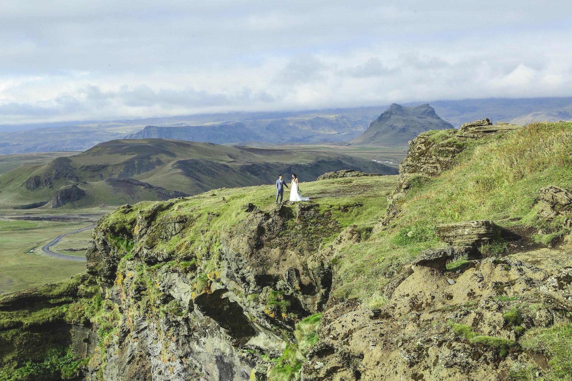Married couple standing on a mountain in Iceland.