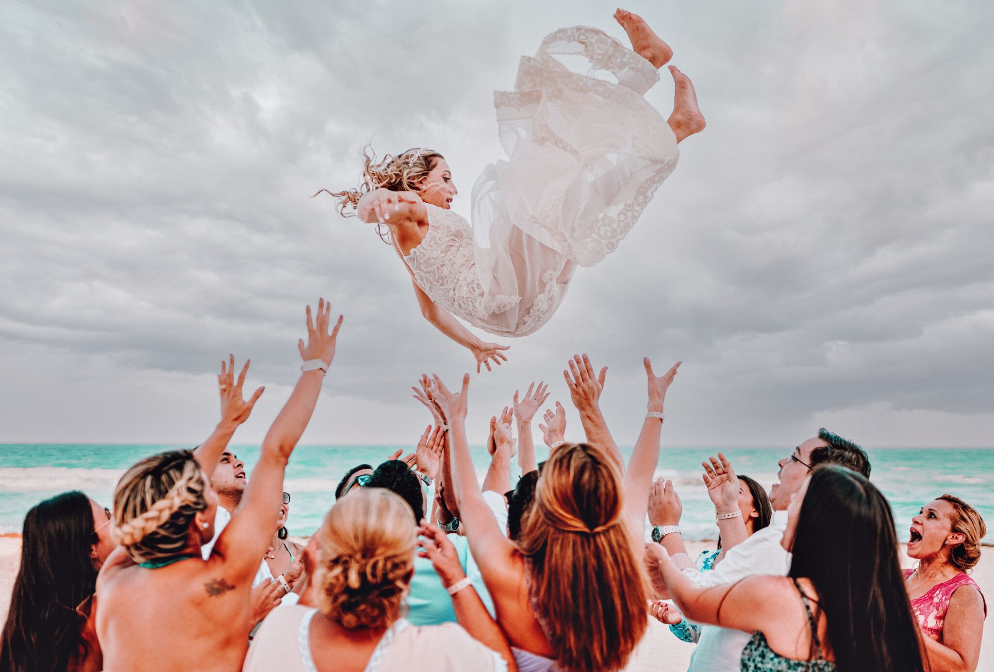 A bride being thrown in the air in Cancun, Mexico