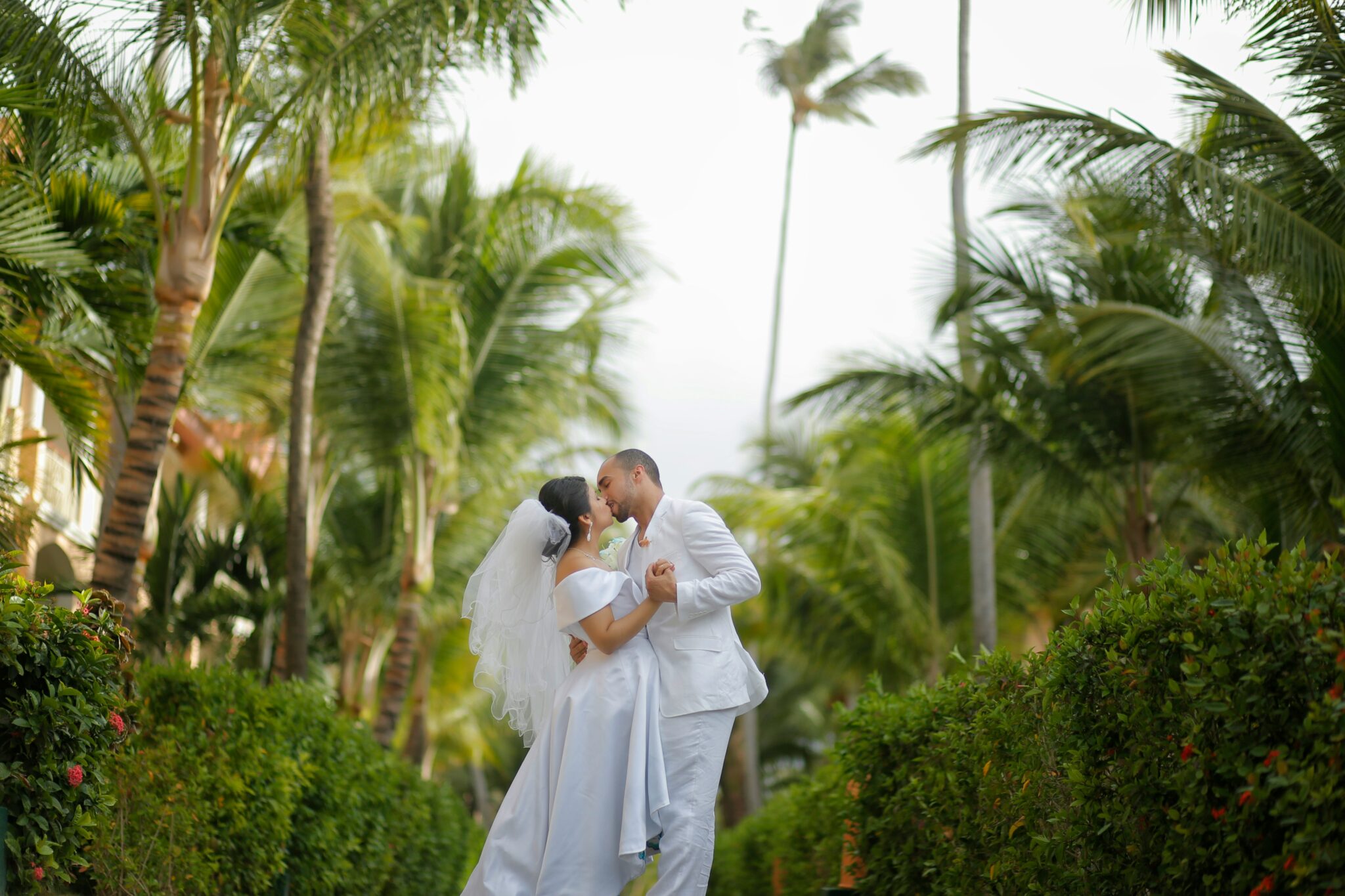 couple kissing with a tropical background