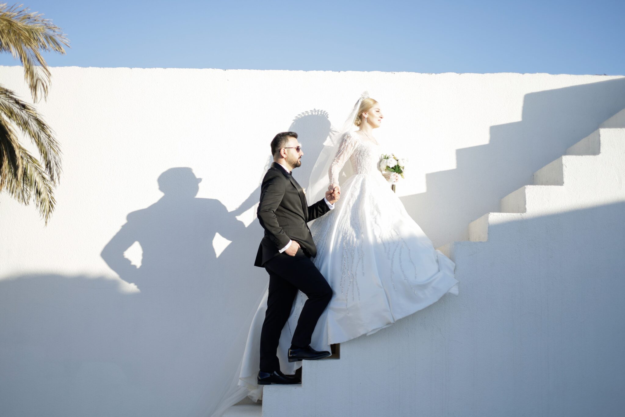 A couple going up white washed stairs in Greece