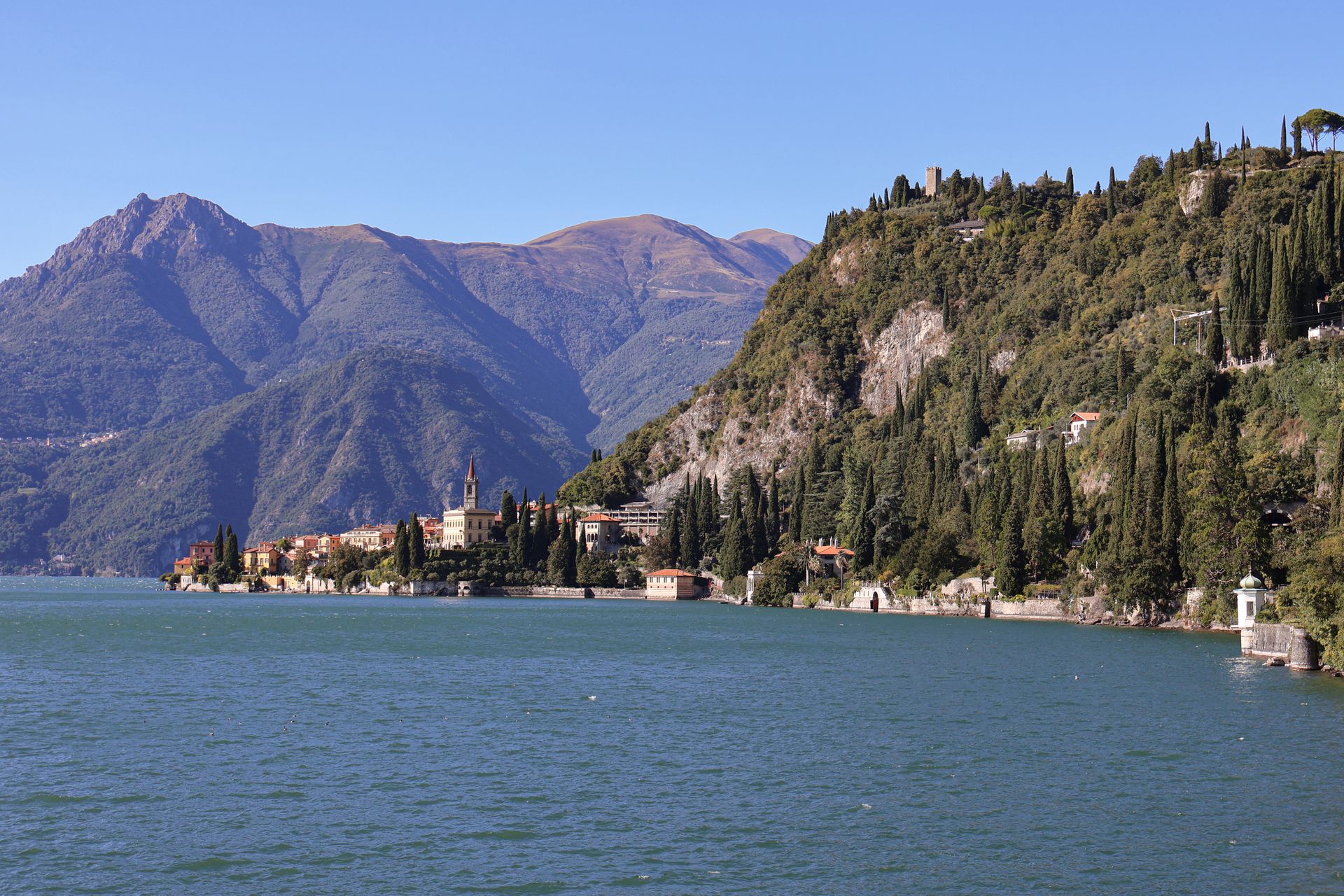 Lake Como, Italy villas on lakeside with views of mountains in background.