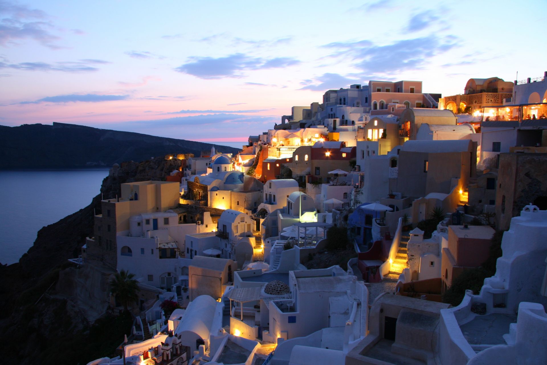 Santorini lit up by lights at dawn.