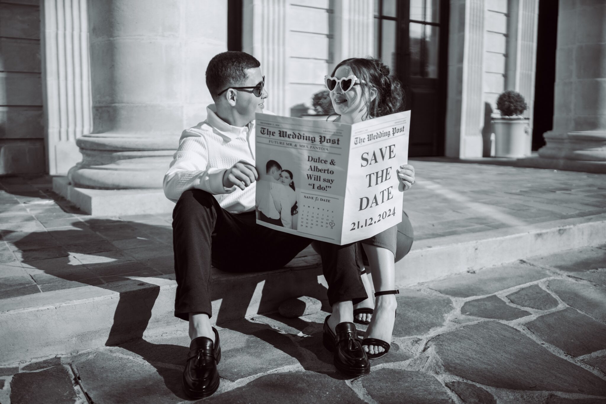 A couple holding save the date newspaper